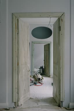 Rooms under renovation with floors and doorways protected by dust sheets