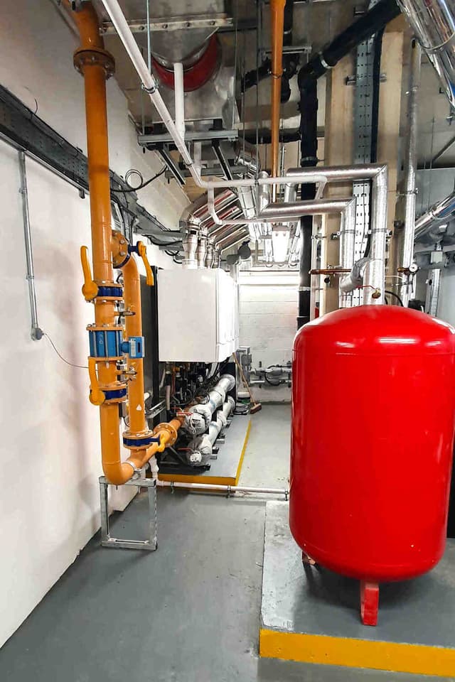 Yellow gas supply pipework beside a bank of boilers