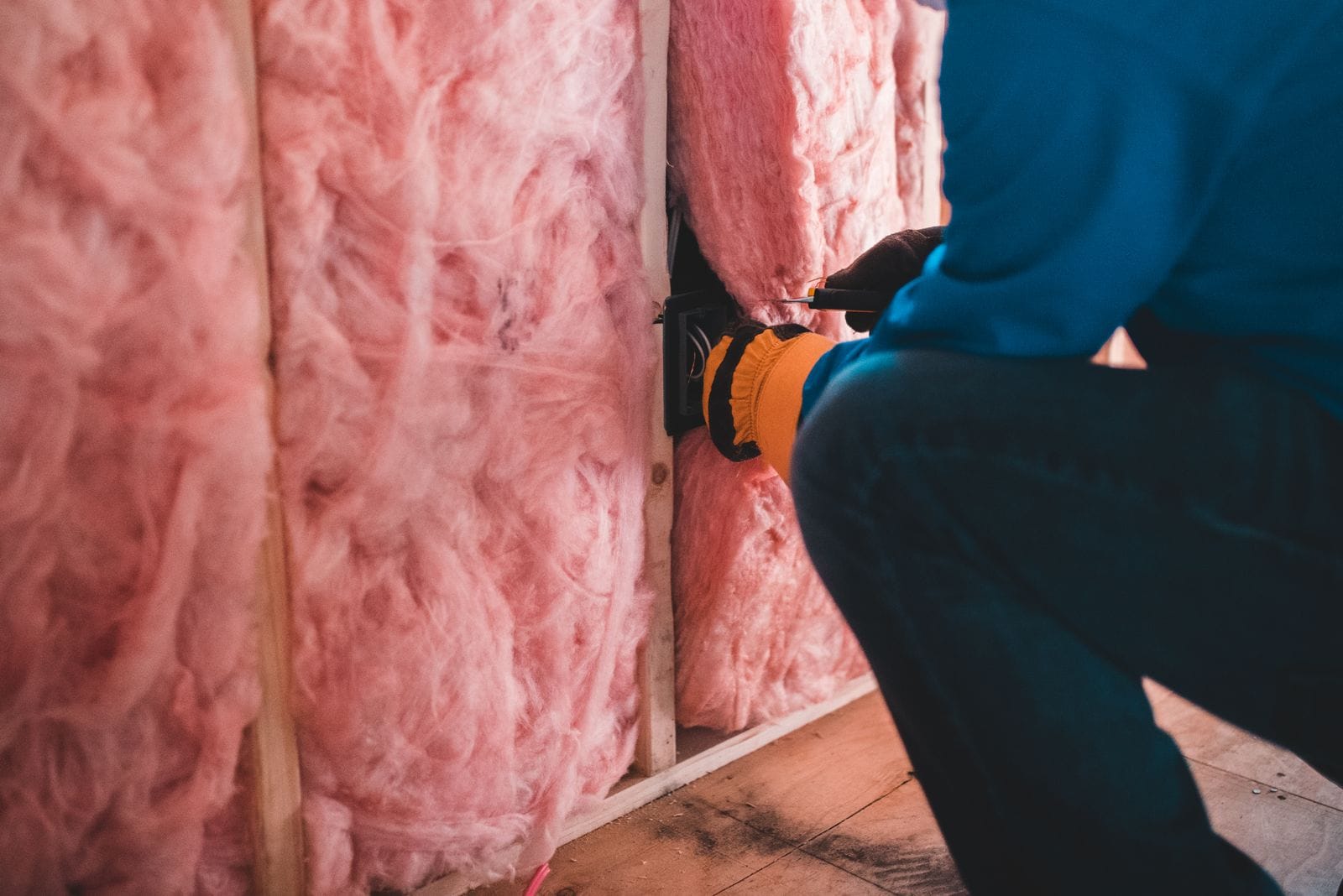 Mineral-wool insulation being fitted between wall studs