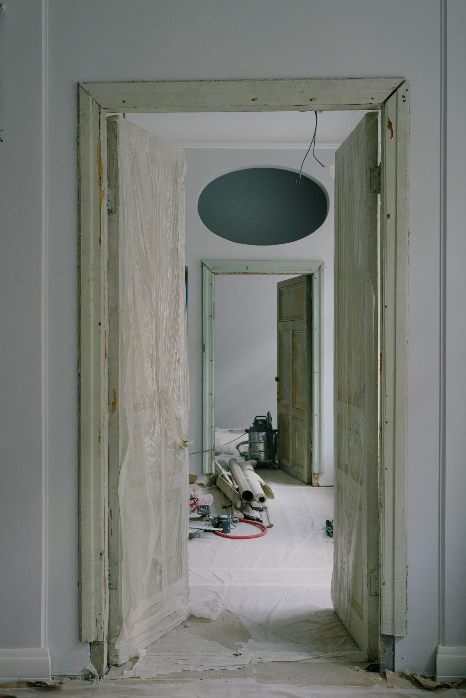 Rooms under renovation with floors and doorways protected by dust sheets