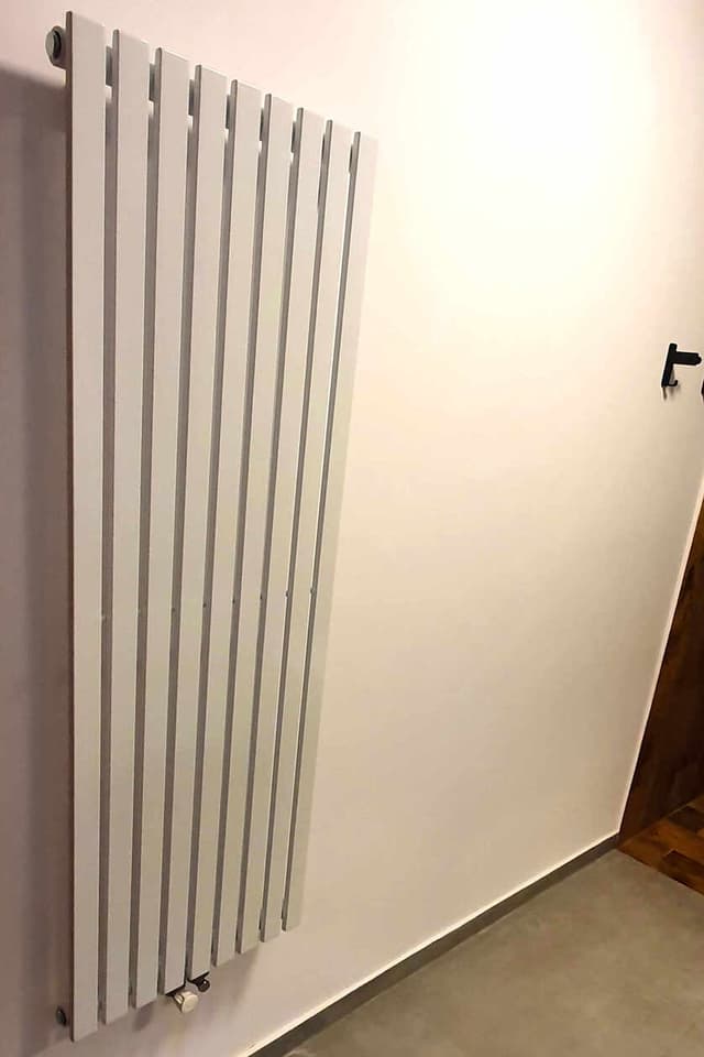 Calorifer vertical montat lângă o ușă